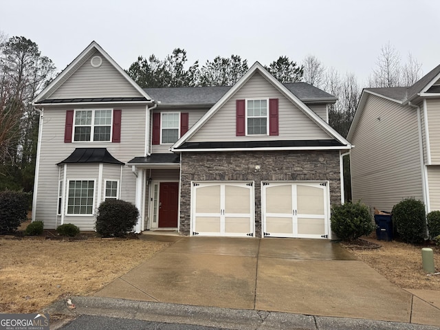 traditional-style house featuring stone siding, driveway, and an attached garage