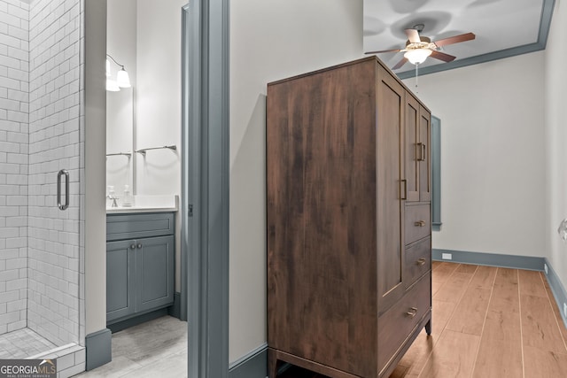 bathroom with ceiling fan, a stall shower, wood finished floors, and vanity