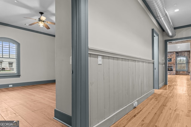 corridor featuring baseboards and wood finished floors