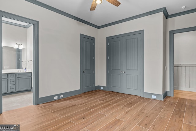 unfurnished bedroom with baseboards, connected bathroom, light wood-style flooring, ornamental molding, and a closet