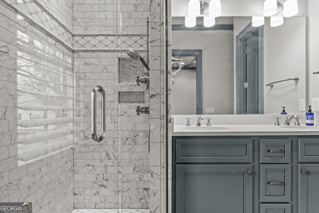 bathroom with double vanity, a stall shower, and a sink