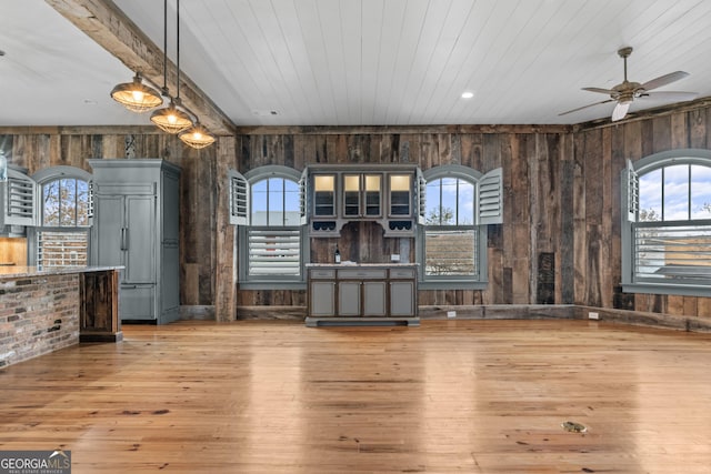 interior space featuring a healthy amount of sunlight, wooden ceiling, wooden walls, and wood finished floors