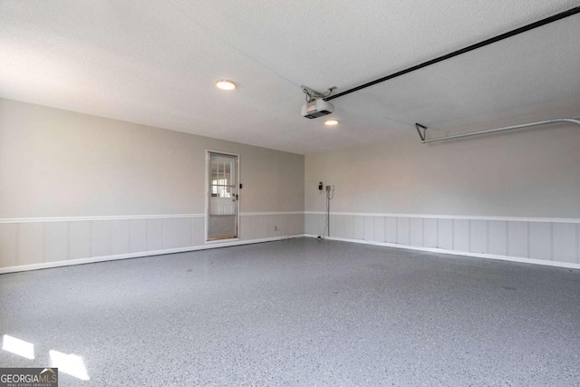 garage with wainscoting and a garage door opener