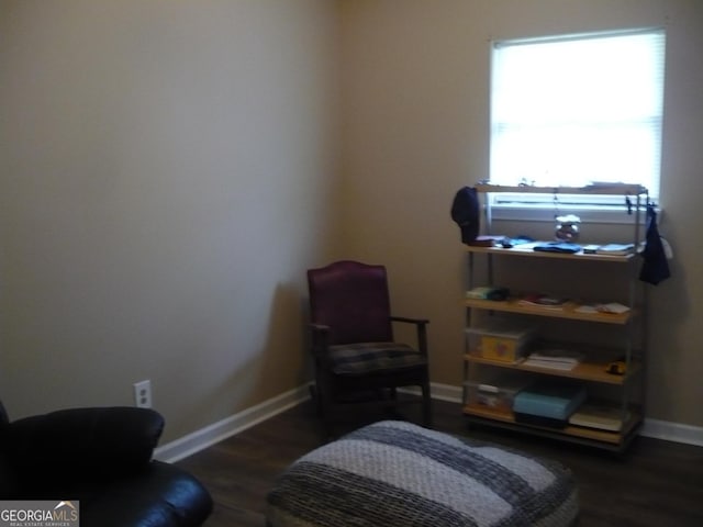 living area with dark wood-style flooring and baseboards