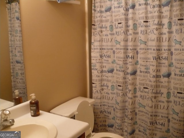 bathroom featuring a shower with curtain, vanity, and toilet