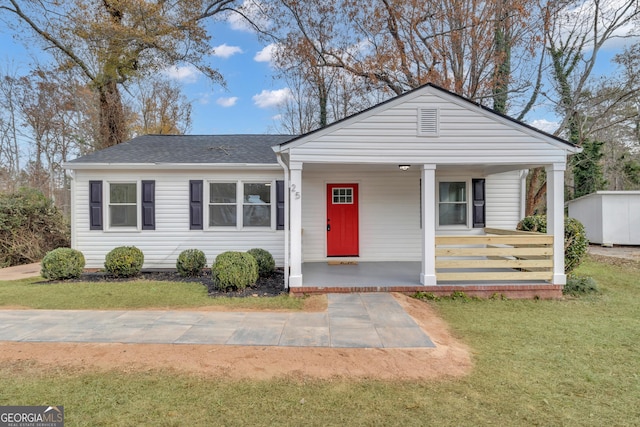 view of front of property with covered porch, a front lawn, and roof with shingles