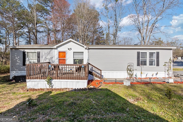 view of front of property featuring a deck and a front lawn