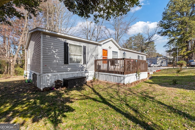 manufactured / mobile home with a deck and a front yard