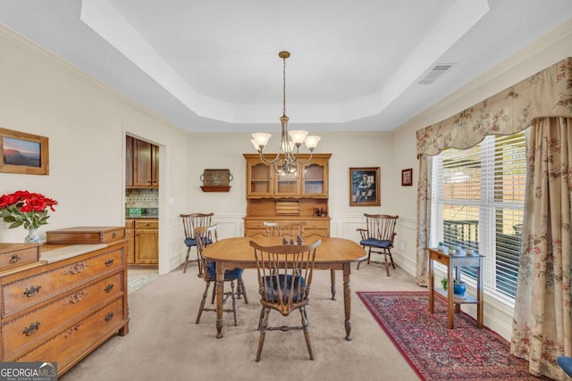 dining room featuring visible vents, a raised ceiling, a notable chandelier, and light colored carpet