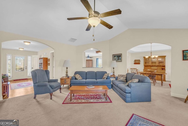 living area with arched walkways, light carpet, ceiling fan with notable chandelier, baseboards, and vaulted ceiling