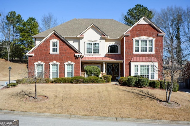 traditional-style home featuring brick siding and a front lawn