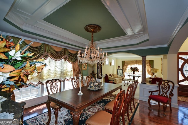 dining area with a healthy amount of sunlight, ornate columns, and a raised ceiling