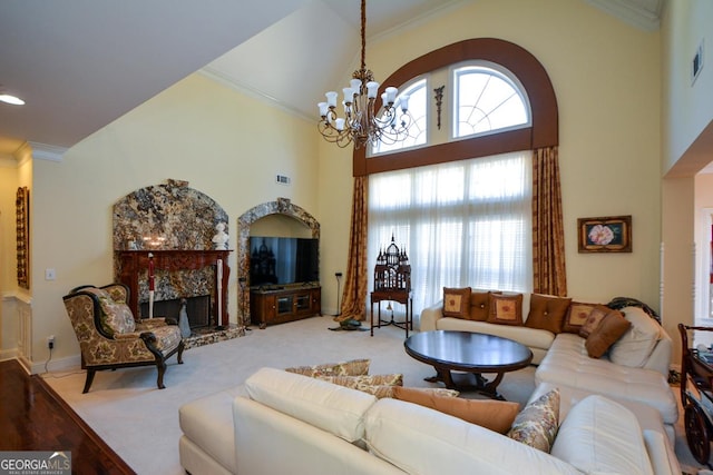 living area with carpet, crown molding, a towering ceiling, a premium fireplace, and a chandelier