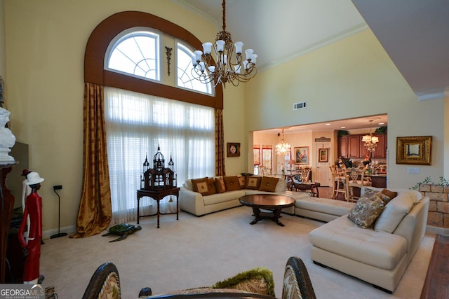 living area featuring carpet, a healthy amount of sunlight, visible vents, and an inviting chandelier