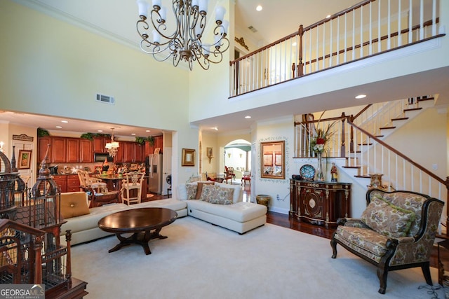 living area with arched walkways, visible vents, stairway, an inviting chandelier, and ornamental molding