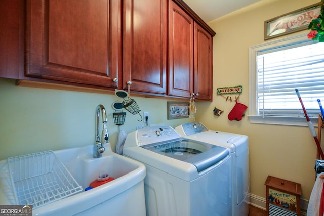 laundry area featuring washer and dryer, cabinet space, and a sink