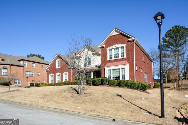 view of front of property featuring brick siding and a front yard