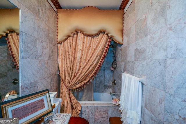 bathroom with tiled shower / bath combo and tile walls