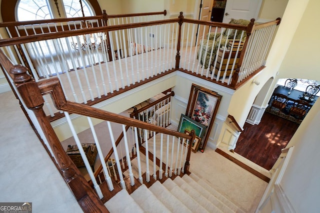 stairway with carpet and a chandelier