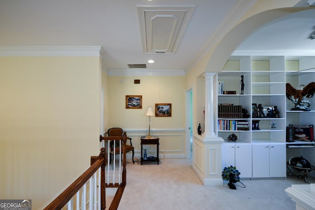 hall with light carpet, visible vents, arched walkways, crown molding, and ornate columns