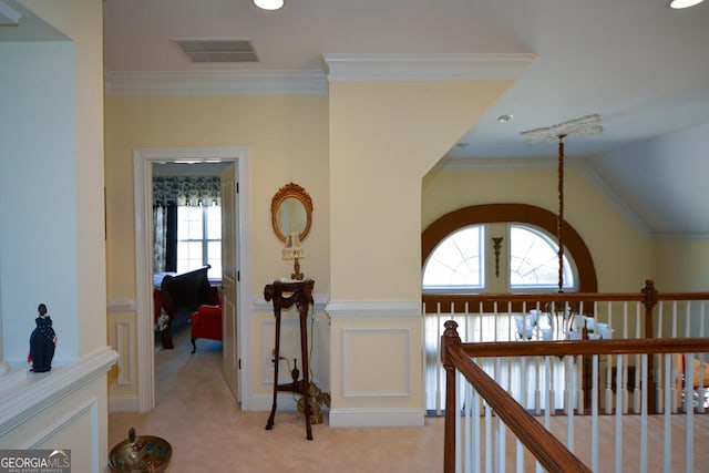 hall featuring light carpet, ornamental molding, lofted ceiling, and visible vents