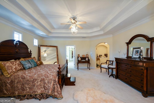 bedroom with light carpet, arched walkways, a raised ceiling, ceiling fan, and ornamental molding