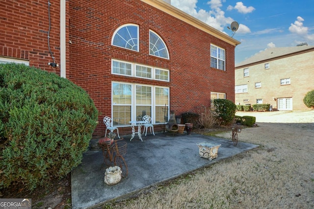 rear view of house featuring a patio area and brick siding