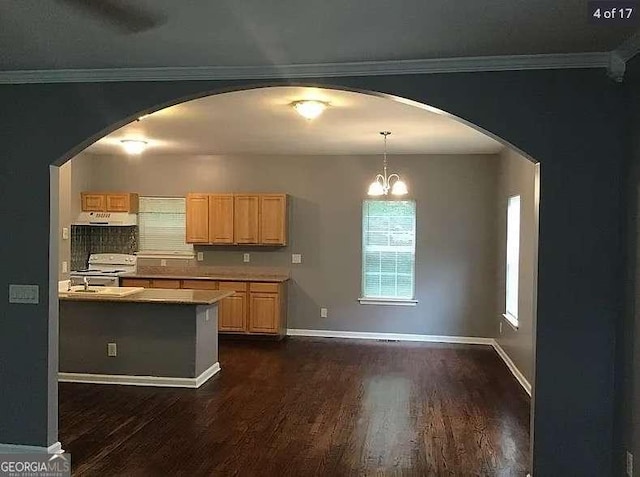 kitchen featuring arched walkways, light countertops, light brown cabinetry, and electric stove