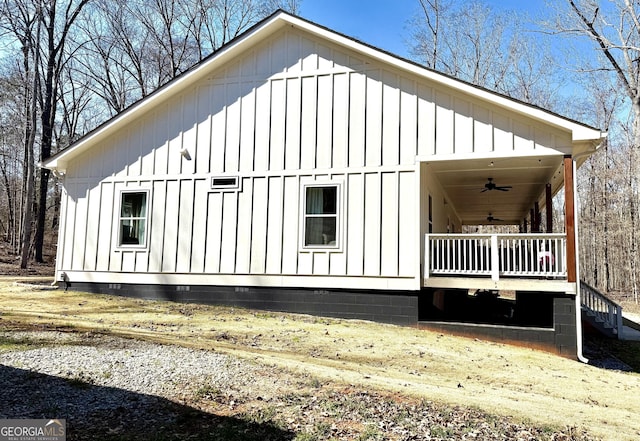 view of side of home featuring board and batten siding, covered porch, and ceiling fan