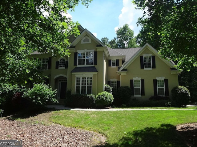 view of front of house with stucco siding and a front yard