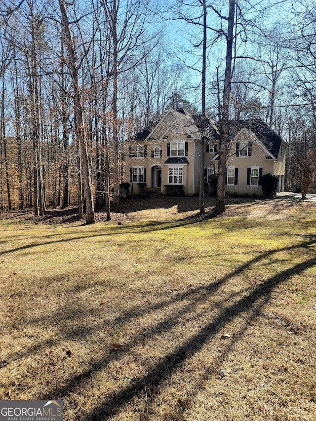 view of front facade with a front yard and stucco siding