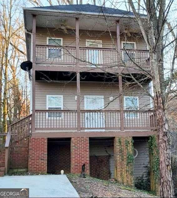 back of property with a balcony and brick siding