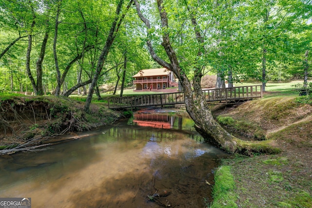 surrounding community with a forest view and a water view