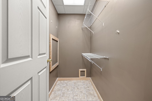 walk in closet featuring a paneled ceiling and light tile patterned flooring