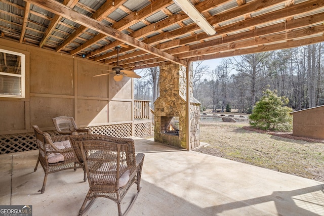 view of patio / terrace with an outdoor stone fireplace and a ceiling fan