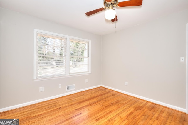 empty room featuring light wood-style floors, baseboards, visible vents, and a ceiling fan