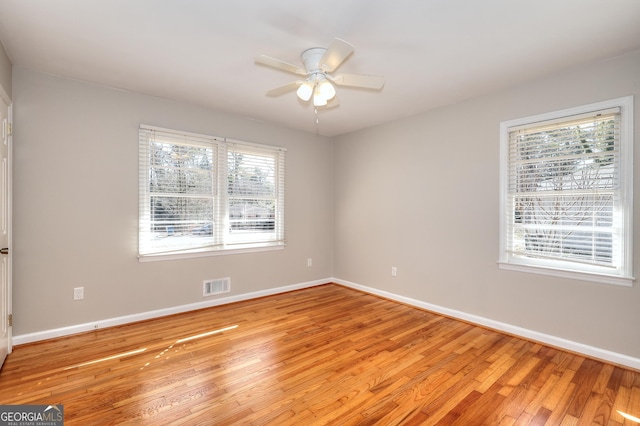 empty room featuring baseboards, visible vents, ceiling fan, and light wood finished floors