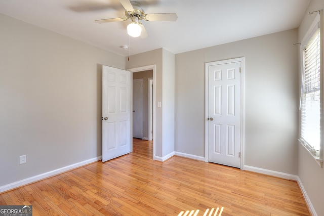 unfurnished bedroom with light wood-style floors, ceiling fan, and baseboards