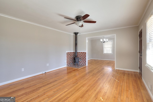 unfurnished living room with a ceiling fan, baseboards, light wood-style floors, a wood stove, and crown molding