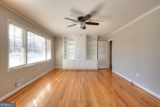 unfurnished bedroom featuring light wood-style floors, visible vents, crown molding, and baseboards