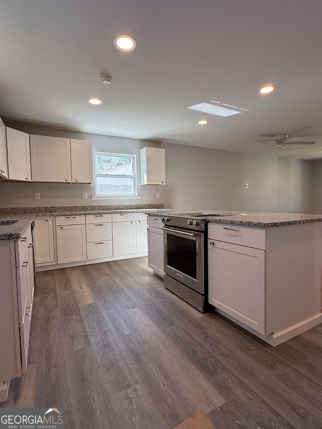 kitchen with recessed lighting, dark wood-type flooring, a ceiling fan, white cabinets, and stainless steel electric range oven