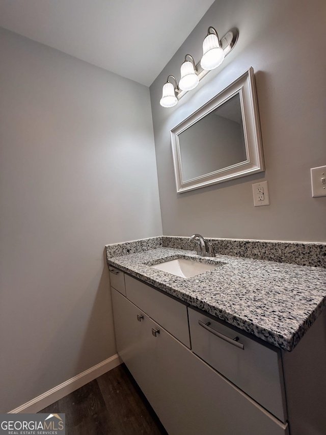 bathroom with vanity, baseboards, and wood finished floors