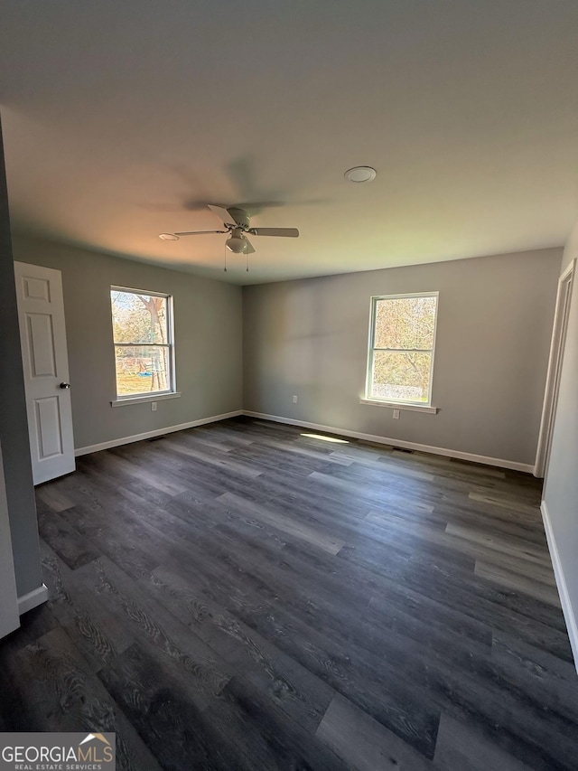 unfurnished bedroom featuring dark wood finished floors, baseboards, and ceiling fan