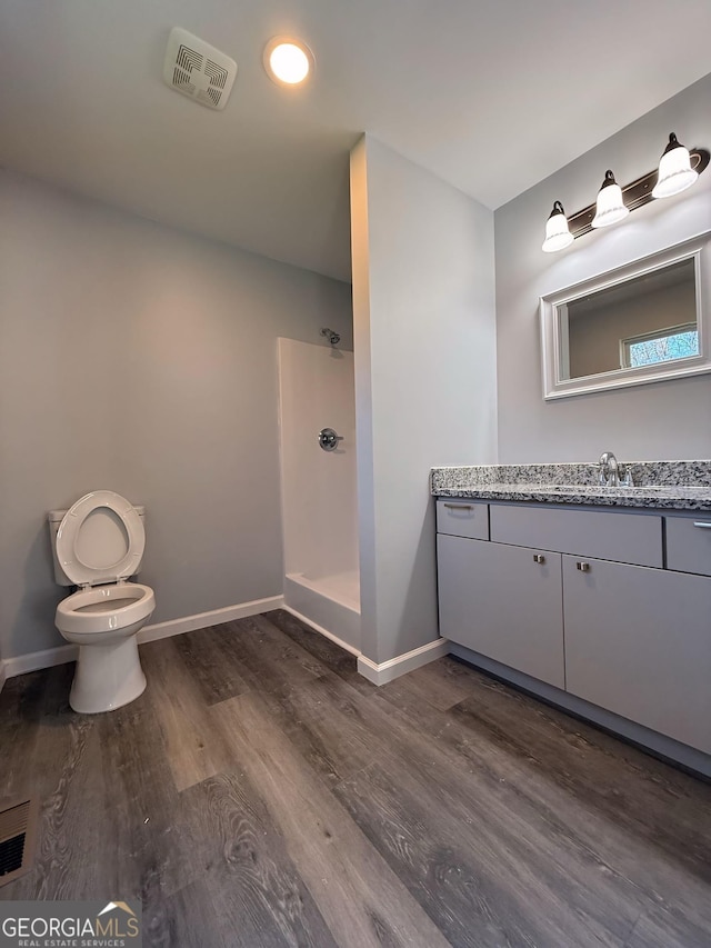 bathroom featuring a stall shower, baseboards, visible vents, and vanity