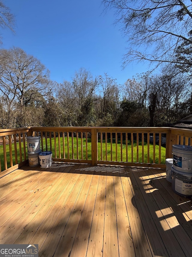 wooden deck featuring a lawn