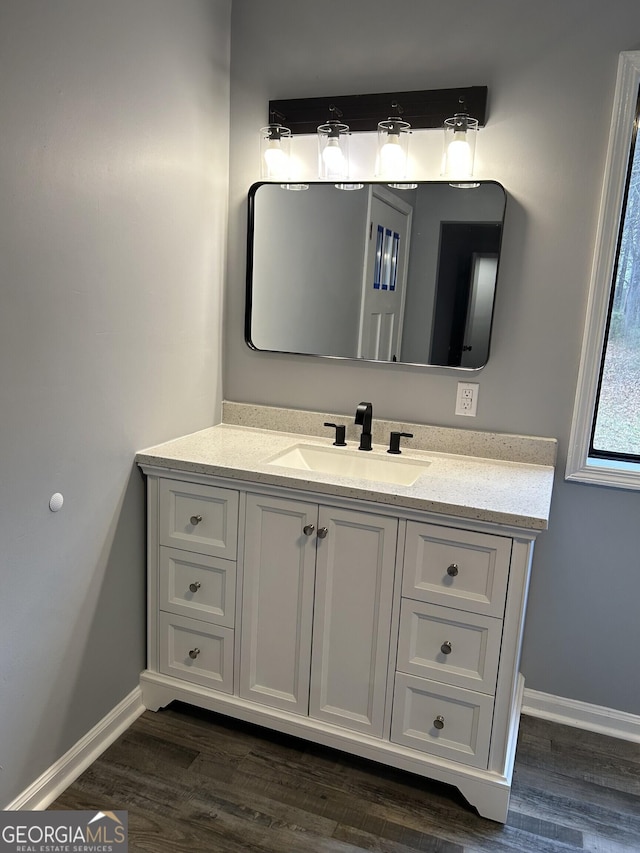 bathroom featuring vanity, baseboards, and wood finished floors