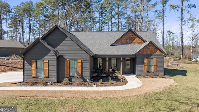 view of front of house featuring roof with shingles and a front yard