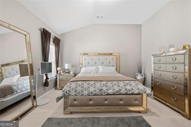 bedroom with baseboards, visible vents, vaulted ceiling, and light colored carpet