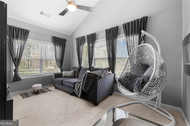 living area with light colored carpet, visible vents, a ceiling fan, high vaulted ceiling, and baseboards