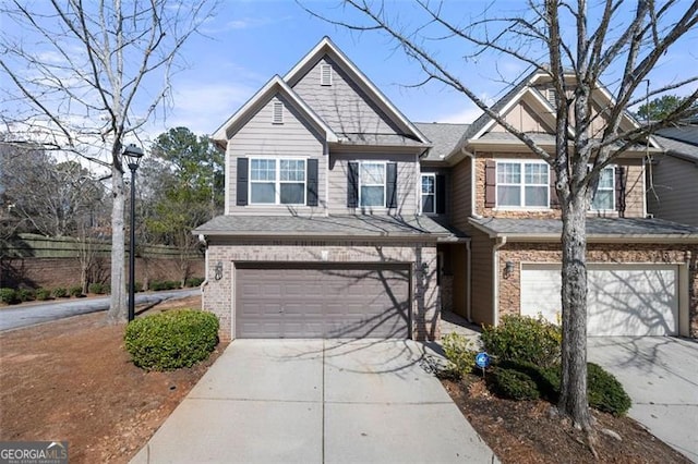 view of front of property with a garage, concrete driveway, brick siding, and fence